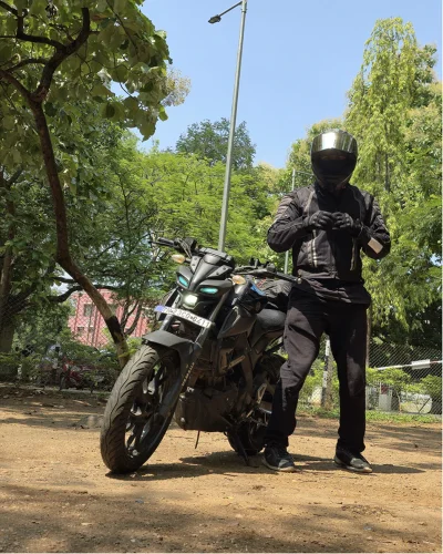 Riding gear on, standing beside the motorcycle