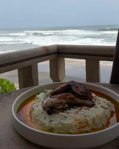 Grilled chicken on rice, with the sea behind
