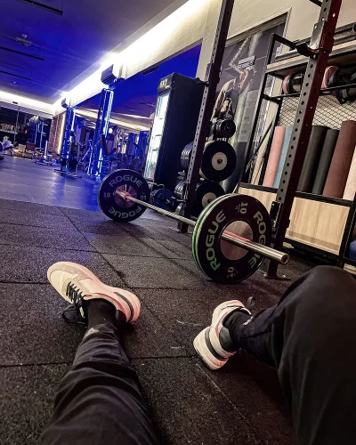 At the gym, next to a loaded barbell
